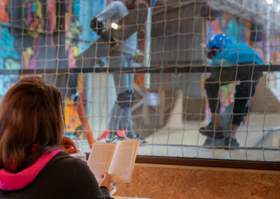 Le bistrot d'Urban Parc - une mère tenant un livre qui regarde le skatepark